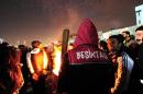 FC Besiktas fans warm up next to a fire on December 16, 2014 in Istanbul during a protest against the trial of fans that took part in mass anti-government protests in Gezi Park in 2013