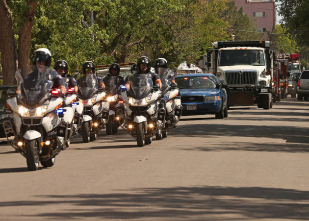 URORA, CO - JULY 21: Aurora Police Department motorcycles escort a dump truck filled with sand and improvised explosive devices removed from James Holmes' apartment July 21, 2012 in Aurora, Colorado. According to police in Aurora, a suburb of Denver, Holmes, 24, is in custody and is suspected of killing 12 people and injuring 59 during a screening of 'The Dark Knight Rises.' Holmes left his apartment filled with 30 various devices and trip wires ment to kill or hurt anyone entering.