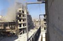 A building burns after shelling at Juret al-Shayah in Homs city