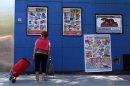 A woman looks at banners with product offers outside a supermarket in Buenos Aires