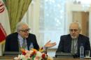 Iranian Foreign Minister Mohammad Javad Zarif (R) sits with International Peace envoy to Syria Lakhdar Brahimi during a joint press conference in Tehran on October 26, 2013
