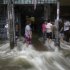 Residents stand as water from the swollen Chao Phraya River flows through a shopping center, located on its bank, in Bangkok, Thailand, Saturday, Oct. 29, 2011. (AP Photo/Altaf Qadri)