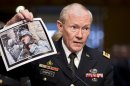 Gen. Martin Dempsey, chairman of the Joint Chiefs of Staff, holds up a photo of a deployed American soldier as he testifies before the Senate Armed Services Committee at his reappointment hearing, on Capitol Hill in Washington, Thursday, July 18, 2013. Dempsey said during congressional testimony Thursday that he has provided President Obama with options for the use of force in Syria. (AP Photo/J. Scott Applewhite)
