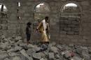 Yemenis walk amid the rubble of a house in the Huthi rebel-held capital Sanaa after it was reportedly hit by a Saudi-led coalition air strike