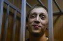 In this photo taken on Tuesday, Oct. 22, 2013, Pavel Dmitrichenko stands in a cage at a court room . Bolshoi ballet dancer Pavel Dmitrichenko, who is accused of being behind an acid attack against Bolshoi's artistic director Sergei Filin, pleaded not guilty to the charges of plotting the assault on Tuesday, Oct. 29, 2013. (AP Photo/Alexander Zemlianichenko)