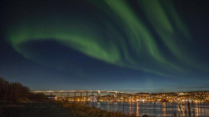 Northern lights (Aurora borelias) are seen on October 20, 2014 over the Norwegian city of Tromsoe, close to a former NATO naval base now sheltering Russian ships