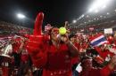 A red-shirted supporter gestures during a rally at Rajamangala national stadium in Bangkok