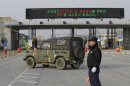 A South Korean military vehicle passes by gates leading to the North Korean city of Kaesong at the customs, immigration and quarantine office near the border village of Panmunjom, which has separated the two Koreas since the Korean War, in Paju, north of Seoul, South Korea, Monday, April 8, 2013. A top South Korean national security official said Sunday that North Korea may be setting the stage for a missile test or another provocative act with its warning that it soon will be unable to guarantee diplomats' safety in Pyongyang. But he added that the North's clearest objective is to extract concessions from Washington and Seoul. (AP Photo/Lee Jin-man)