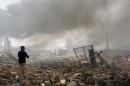 A man walks at a destroyed building at the site of a blast caused by a fire at a weapons storage in eastern Baghdad