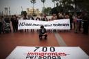 People hold a banner reading "No more deaths in the Mediterranean" during a protest against the current immigration policy of the European Union in Malaga