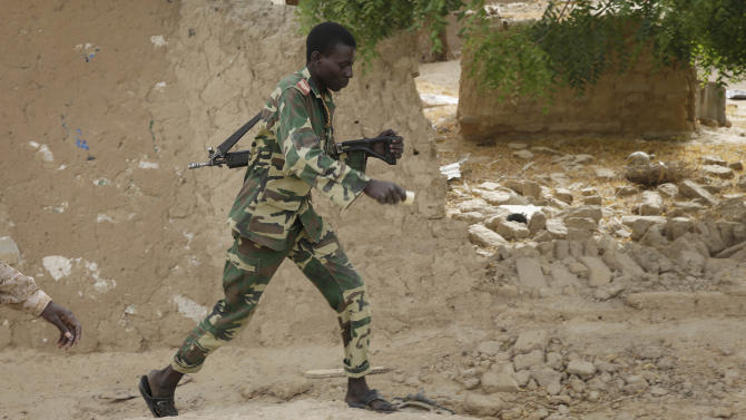 A Chadian soldiers walks in the city of Damasak, Nigeria, Wednesday, March 18, 2015. Damasak was flushed of Boko Haram militants last week, and is now controlled by a joint Chadian and Nigerien force. (AP Photo/Jerome Delay)