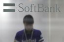 A shop clerk is seen through a window displaying a logo of SoftBank Corp at its branch in Tokyo