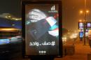 In this Wednesday, June 1, 2015 photo, a billboard in Kuwait City shows the Kuwaiti flag wrapped around a hand, with the slogan: 