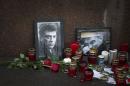 Flowers, votive candles and portraits are seen at the place where Boris Nemtsov, a charismatic Russian opposition leader and sharp critic of President Vladimir Putin, was gunned down on Friday, Feb. 27, 2015 near the Kremlin, in Moscow, Russia, Thursday, March 5, 2015. President Vladimir Putin on Wednesday called the slaying of his top critic a "disgrace" to Russia, while the opposition promised to complete Nemtsov's work on a report documenting evidence of Russian troops' involvement in fighting in eastern Ukraine. (AP Photo/Alexander Zemlianichenko)