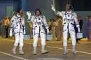 The International Space Station crew members U.S. astronaut Nyberg, Russian cosmonaut Yurchikhin and Italian astronaut Parmitano walk after donning space suits before the launch at the Baikonur cosmodrome