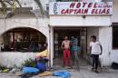 Afghan migrants stand on August 16, 2015 outside the abandoned Captain Elias hotel on the Greek Aegean island of Kos, where migrants arriving to the island have found shelter