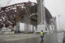 Construction workers assist in the assembly of a gigantic steel-arch to cover the remnants of the exploded reactor at the Chernobyl nuclear power plant in Chernobyl, Ukraine, Tuesday, Nov. 27, 2012. The new safe confinement, a structure that is being built over reactor 4 damaged in 1986 as a result of the world's worst nuclear accident, will cover a hastily built sarcophagus, which was erected shortly after the explosion. (AP Photo/ Efrem Lukatsky)