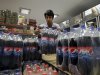 In this picture taken on Saturday, Sept. 8, 2012, Iranian worker Mahmoud Kouhi, adjusts family size bottles of Pepsi beverage, in a grocery store in northern Tehran, Iran. Even after decades of diplomatic estrangement and tightening economic sanctions, American products find their way to the Islamic Republic through back channel exporters, licensing workarounds and straightforward trade in goods not blocked by U.S. embargoes. In Iran, it's possible to check your email on an iPhone, sip a Coke and hit the gym wearing Nikes. (AP Photo/Vahid Salemi)