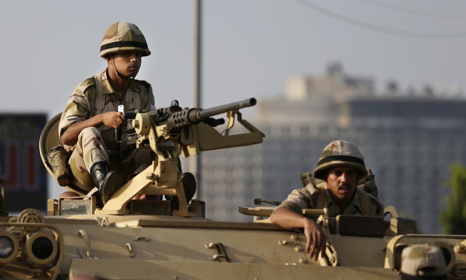 Egyptian army soldiers take their positions on top of their armored vehicle to guard the entrances of Tahrir square, in Cairo, Egypt, Monday, July 8, 2013. Egyptian military officials said gunmen killed at least five supporters of the former president when people tried to storm a military building in Cairo. The official, who declined to be named because he was not authorized to brief reporters, also said a group had tried to storm the headquarters of the Republican Guard. He added that those killed had been supporters of former President Mohammed Morsi camped outside the building in protest at his overthrow. (AP Photo/Hassan Ammar)