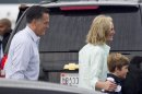 Republican presidential candidate, former Massachusetts Gov. Mitt Romney and his wife Ann, arrive to board their plane to Tampa with one of their grandchildren on Tuesday, Aug. 28, 2012 in Bedford, Mass. (AP Photo/Evan Vucci)