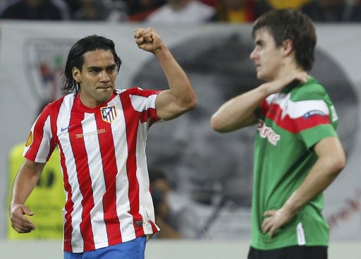 Atletico Madrid's Falcao celebrates his second goal as he passes Athletic Bilbao's Jon Aurtenetxe during their Europa League final soccer match at the National Arena in Bucharest