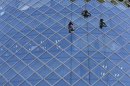 Workers clean windows of an office building in Tokyo's business district