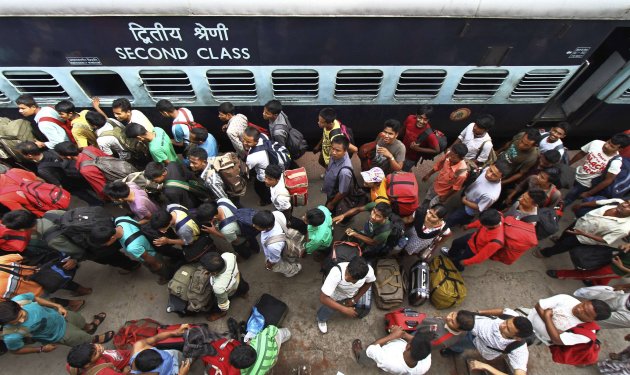 People from India's northeastern states, walk at the platform upon their return from southern Indian states, at the railway station in Guwahati in the northeastern Indian state of Assam August 18, 2012. Indian Prime Minister Manmohan Singh assured migrants from the northeast that they were safe as thousands fled Mumbai, Bangalore and other cities on Friday, fearing a backlash from violence against Muslims in Assam. REUTERS/Utpal Baruah (INDIA - Tags: TRANSPORT RELIGION POLITICS CIVIL UNREST)