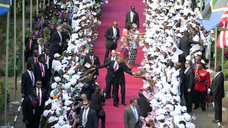 President Barack Obama and Tanzanian President Jakaya Kikwete walk in front of first lady Michelle Obama and Tanzanian first lady Salma Kikwete greeting the cheering crowd as they arrive at the State House in Dar es Salaam, Tanzania, Monday, July 1, 2013. (AP Photo/Carolyn Kaster, Pool)