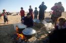 Displaced people from the outskirts of Mosul cook in the town of Bashiqa