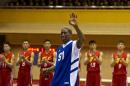 Dennis Rodman waves to North Korean leader Kim Jong Un, seated above in the stands, after singing Happy Birthday to Kim before an exhibition basketball game with U.S. and North Korean players at an indoor stadium in Pyongyang, North Korea on Wednesday, Jan. 8, 2014. (AP Photo/Kim Kwang Hyon)