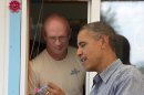 President Barack Obama talks with Steven Holt owner of Tropical Sno, after he purchased a snow cone, Monday, Aug. 13, 2012, in Denison, Iowa, during a three day campaign bus tour through Iowa. (AP Photo/Carolyn Kaster)