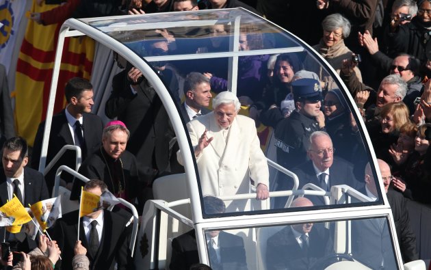Pope Benedict XVI greets pilgrims in St. Peter's Square at the Vatican, Wednesday, Feb. 27, 2013 for the final time before retiring, waving to tens of thousands of people who have gathered to bid him farewell Benedict was driven around the square in an open-sided vehicle, surrounded by bodyguards. At one point he stopped to kiss a baby handed up to him by his secretary. (AP Photo/Luca Bruno)