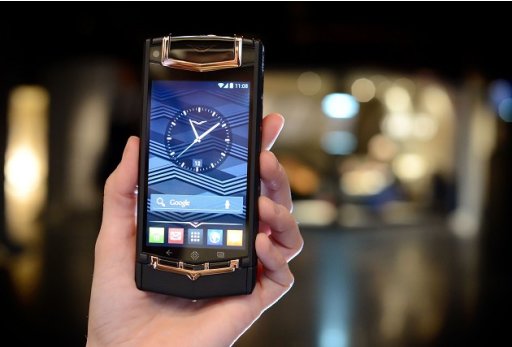 A woman holds a Black PVD Titanium Red Gold and Mixed Metals Vertu Ti smartphone, which retails for 14,200 pounds