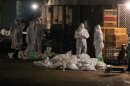 Tecnici in tute e maschere protettive sopprimono gli animali in un mercato del pollame di Shanghai in cui è stato rilevato il ceppo H7N9 dell'influenza aviaria