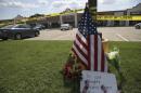 Handout of police tape and a makeshift memorial sit on the lawn in front of an Armed Forces Career Center in this handout photo provided by the U.S. Navy, where earlier in the day a gunman opened fire, injuring one U.S. Marine in Chattanooga