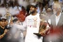 Heat's James holds the Larry O'Brien Trophy and Bill Russell MVP Trophy after his team defeated the Spurs in Game 7 to win the NBA Finals basketball playoff in Miami