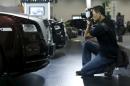 A man takes pictures of a Rolls-Royce Wraith car at the Imported Auto Expo in Beijing