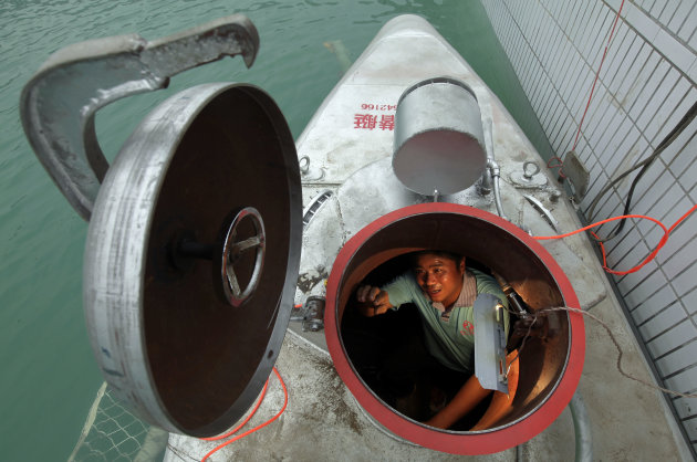 Zhang Wuyi sits in his double-seater submarine during a test operation at an artificial pool near a shipyard in Wuhan
