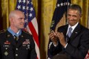 President Barack Obama applauds after awarding US Army Staff Sgt. Ty M. Carter, left, the Medal of Honor for conspicuous gallantry, Monday, Aug. 26, 2013, during a ceremony in the East Room of the White House in Washington. Carter received the medal for his courageous actions while serving as a cavalry scout with Bravo Troop, 3rd Squadron, 61st Cavalry Regiment, 4th Brigade Combat Team, 4th Infantry Division, during combat operations in Kamdesh District, Nuristan Province, Afghanistan on Oct. 3, 2009. Carter is the fifth living recipient to be awarded the Medal of Honor for actions in Iraq or Afghanistan. (AP Photo/Jacquelyn Martin)