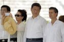 Peng Liyuan takes a photograph as Xi Jinping talks with Enrique Pena Nieto during a visit at the archaeological site of Chichen Itza in the peninsula of Yucatan