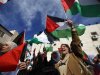 Palestinians wave flags during a rally in support of President Abbas' efforts to secure a diplomatic upgrade at the United Nations, in Ramallah