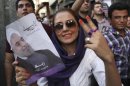 A female supporter of Iranian presidential candidate Hasan Rowhani flashes a victory sign as she holds his poster during a celebration gathering in Tehran, Iran, Saturday, June 15, 2013. Moderate cleric Hasan Rowhani was declared the winner of Iran's presidential vote on Saturday after gaining support among many reform-minded Iranians looking to claw back a bit of ground after years of crackdowns. (AP Photo/Vahid Salemi)