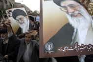 In this picture taken on Friday, Nov. 16, 2012, Iranian worshippers hold posters showing supreme leader Ayatollah Ali Khamenei, and late revolutionary founder Ayatollah Khomeini, in a pro-Palestinian demonstration after Friday prayer, in Tehran, Iran. (AP Photo/Vahid Salemi)