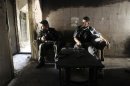 Members of the Free Syrian Army sit on a sofa inside a house in the old city of Aleppo