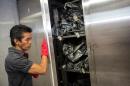 A forensic staffer opens the door of morgue's cold chambers full of body bags in Acapulco, Mexico on July 13, 2016