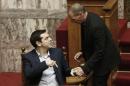 Greek Minister Alexis Tsipras left, chats with his Finance Minister Yanis Varoufakis, during the vote for the president of Greece's parliament in Athens, on Friday, Feb. 6, 2015. Barely 10 days after radical left-wing Syriza was swept to power in Athens, analysts expect a compromise over Greece's debts to emerge, allowing it to remain a member of the 19-country eurozone. The finance ministers of the 19-country eurozone are to meet at a special meeting Wednesday on the eve of a summit of European Union leaders to discuss Greece's debts.(AP Photo/Petros Giannakouris )