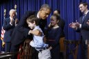 Il presidente Usa Barack Obama alla Casa Bianca abbraccia un bambino dopo aver firmato una serie di proposte per ridurre e controllare maggiormente la diffusione di armi da fuoco in Usa