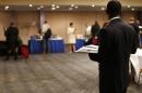 A job seeker stands in a room of prospective employers at a career fair in New York City