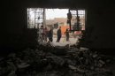 Iraquíes ante un edificio destrozado tras explotar una bomba en Hurriyah, barrio chií de Bagdad, el miércoles