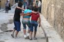 Boys help their injured friend after an airstrike on Aleppo's rebel held al-Fardous district